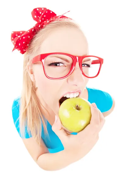 Смешная девушка кусает яблоко, изолированное на белом, рыбий глаз выстрел — стоковое фото