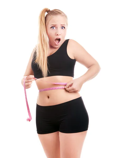 Size 40 girl is shocked by measuring her waist — Stock Image Size 40 girl is shocked by measuring her waist Stock Picture
