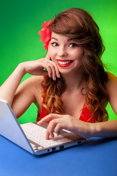 Colorful portrait of smiling young woman working on a laptop Stock Image