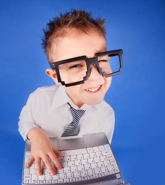 Menino de cinco anos com um computador portátil — Fotografia de Stock