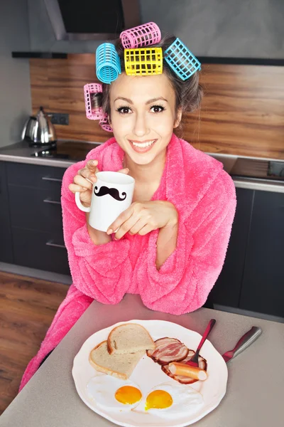 Jovem dona de casa atraente está tomando um café da manhã — Fotografia de Stock