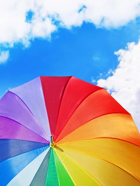 Guarda-chuva arco-íris no fundo do céu azul — Fotografia de Stock