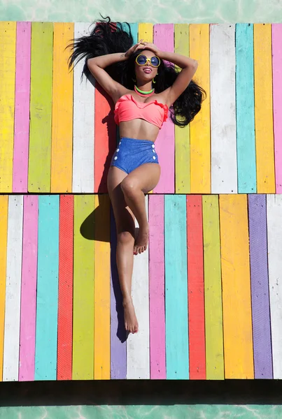 Mujer bronceadora en un muelle de madera — Foto de Stock