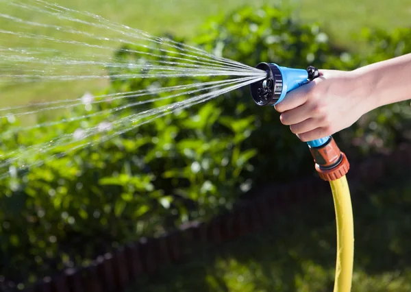 Frauenhand mit Gartenschlauch — Stockfoto