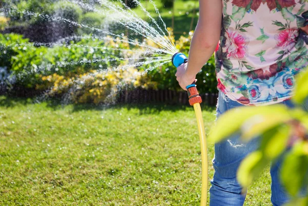 Frau mit Gartenwasserschlauch — Stockfoto