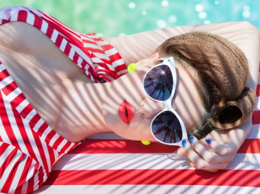 Yüzme havuzunun kenarında uzanmış kadını