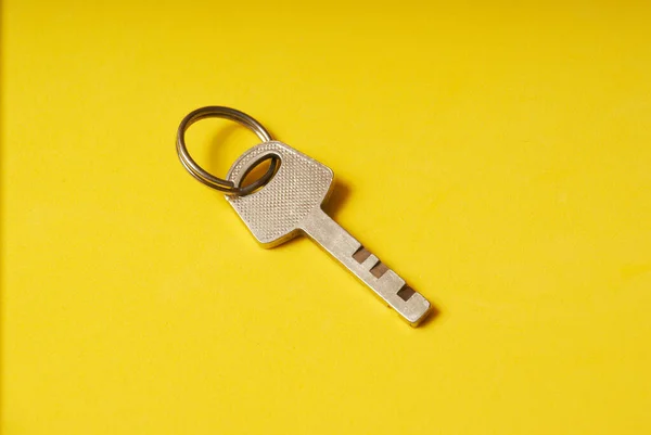 La llave de la cerradura sobre un fondo amarillo. —  Fotos de Stock