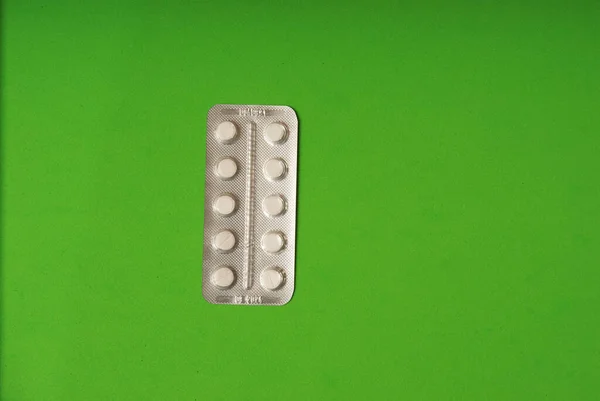Orvosi tabletták zöld háttér felülnézet — Stock Fotó