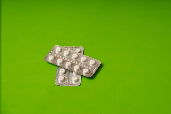 Медицинские таблетки на зеленом фоне вид сверху — стоковое фото