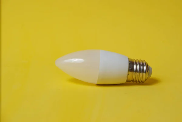 Biała żarówka LED na żółtym tle — Zdjęcie stockowe