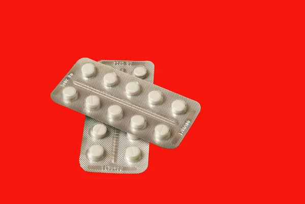 Медицинские таблетки на красном фоне вид сверху — стоковое фото