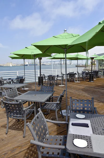 Restaurant en groen paraplu's aan de waterkant. — Stockfoto