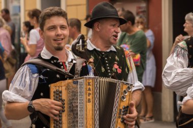 Villach, Austria - August 6, 2022: Musicians enjoy the procession of 'Villacher Kirchtag', the largest traditional folk festival in Austria, after some years of cancellation due to Covid.