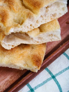 Taze dilimlenmiş organik İtalyan düz ekmekli Focaccia pizzası fırından yeni çıktı ve yüksek açılı görmeye hazır..