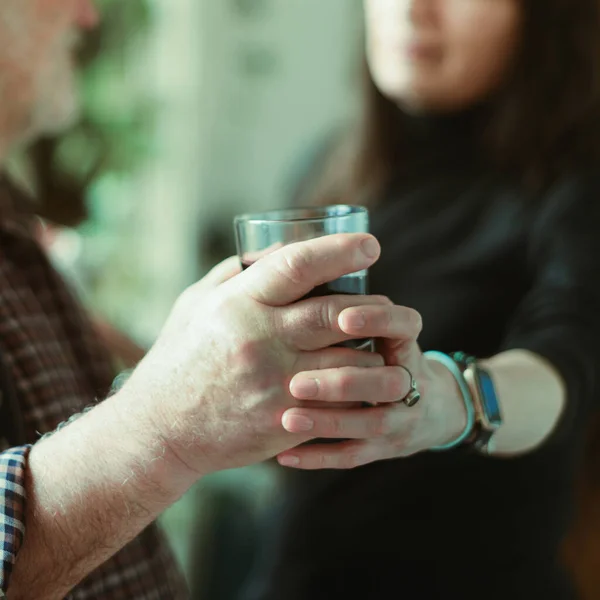 Kaukasischer Mann trinkt Wein und betrinkt sich zu Hause und stresst jüngere hispanische Ehefrau - Konzept für Alkoholismus und häusliche Gewalt — Stockfoto