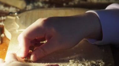 Luthier, atölyedeki bankta çiğ ahşap keman tabağı ve parmak uçağıyla çalışıyor.