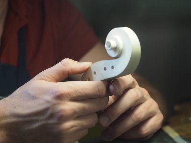 Luthier 'in elinde keman kafası tasarımı ve oyması var.