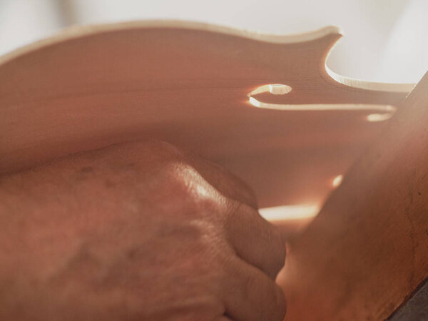 violinmaker cutting and sawing golden period cremonese violin model fholes with a blade with precision