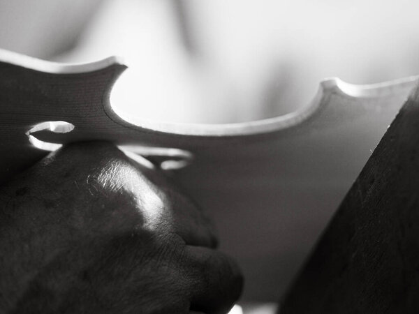 violinmaker cutting and sawing golden period cremonese violin model fholes with a blade with precision