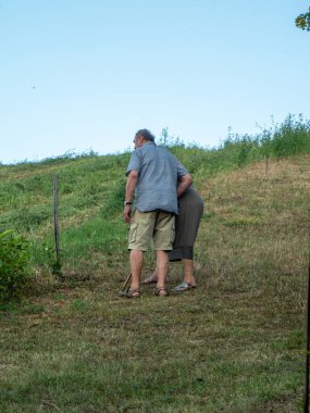 Bahçe ve çiftlikte yaz mevsiminde uçan direkli yaşlı bir adam.