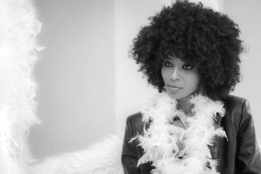 Mutlu gülüşü olan genç ve çekici Afrikalı kadın stüdyoda eğleniyor.