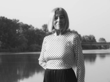 single female pensioner having fun in a park - aging free and wellness concept