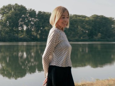 single female pensioner having fun in a park - aging free and wellness concept