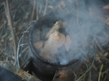 starting a bee smoker before harvesting honey hives in the farm.