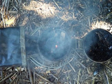 starting a bee smoker before harvesting honey hives in the farm.