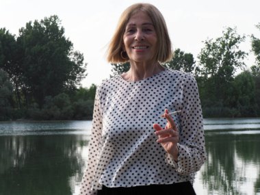 Kadın emekli parkta eğleniyor ve sigara içiyor - yaşlanma ve sağIık kavramı