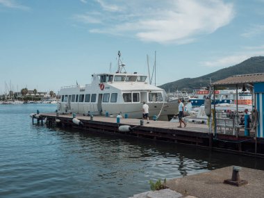 People walking near the sea and boats