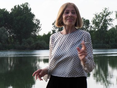 Kadın emekli parkta eğleniyor ve sigara içiyor - yaşlanma ve sağIık kavramı