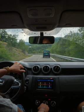 Beautiful business lady driving her car a cloudy day in summertime