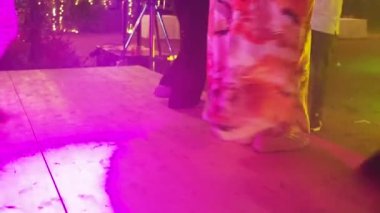 İnsanlar geceleri dans ediyor. Bacaklar ve ayaklar. Renkli ışık diskotek havası. Yüksek kalite 4k görüntü