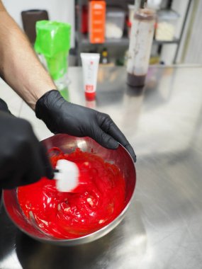 Şef, profesyonel mutfak laboratuarında kremalı pasta yapıyor.