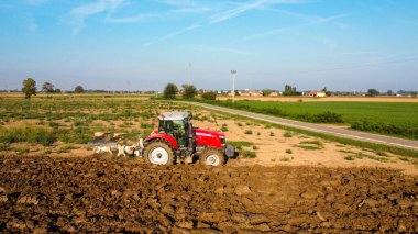 Hava manzaralı traktör dronu kırsal alanda toprağı sürüyor..