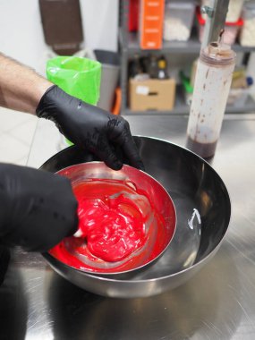 Şef, profesyonel mutfak laboratuarında kremalı pasta yapıyor.