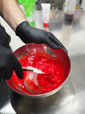 Şef, profesyonel mutfak laboratuarında kremalı pasta yapıyor.