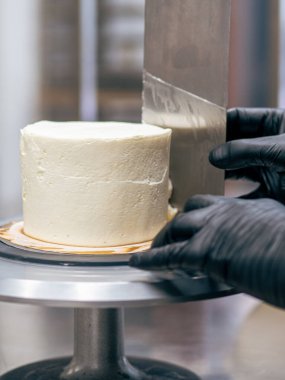 Profesyonel fırıncı çikolatalı ve kremalı pastayı tuzlu karamel ile süslüyor.