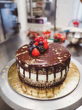 Laboratuvarda altın ve böğürtlenli bir çikolatalı pasta var.