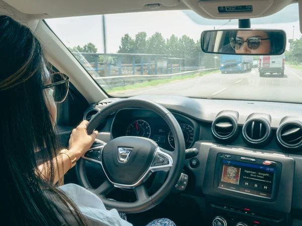 Beautiful business lady driving her car a cloudy day in summertime