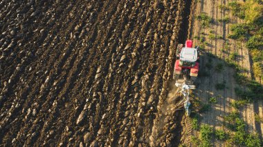 Hava manzaralı traktör dronu kırsal alanda toprağı sürüyor..