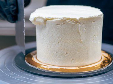 Profesyonel fırıncı çikolatalı ve kremalı pastayı tuzlu karamel ile süslüyor.