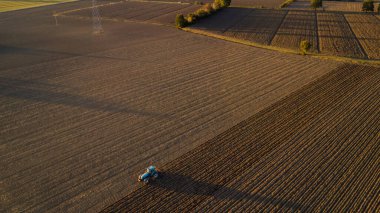 Taşrada araziyi düzleştiren traktörlü çiftçi.