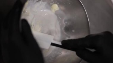 Şef, profesyonel mutfak laboratuarında leylak kremalı pasta yapıyor.