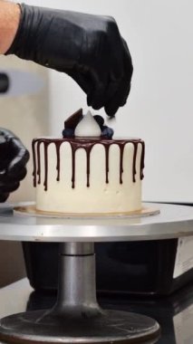 Şef, profesyonel mutfak laboratuarında kremalı pasta yapıyor.