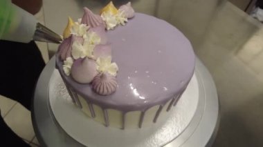 Şef leylak kremalı pasta için ganache dolduruyor.