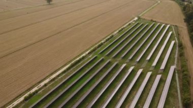 Tarım çiftliğindeki güneş panelleri temiz elektrik enerjisi yaratmak için güneş ışığıyla aydınlatılıyor.