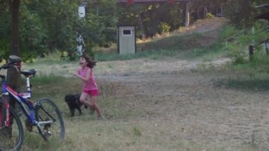 Kız oynuyor ve köpeği gezdiriyor.