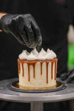 Kek tasarımcısı bir kekle iş yerinde.